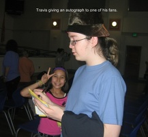 Travis signing an autograph for a fan.  Remember the little people son!